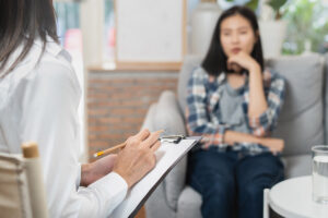 Woman sits and talks to therapist while wondering "what is psychotherapy?"