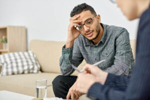 Therapist takes notes while client asks if trauma therapy is effective