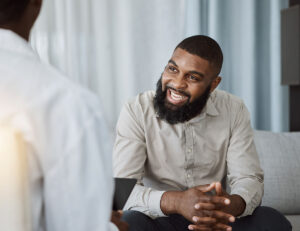Man smiles while listening to holistic therapy examples
